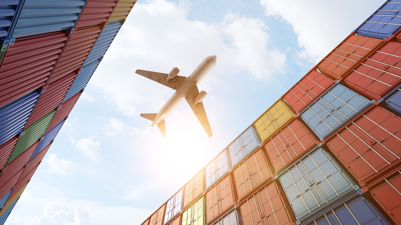 freight plane flying over containers