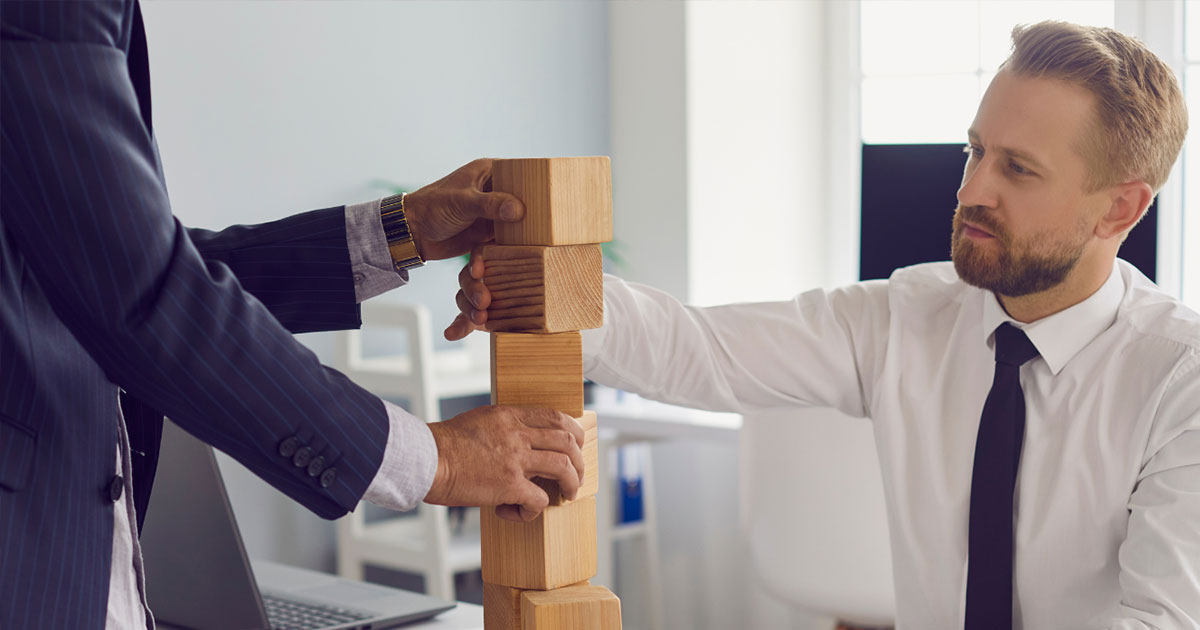 business men stacking blocks